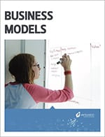 A woman writes on a whiteboard about free entrepreneurship curriculum, with visible text and diagrams.