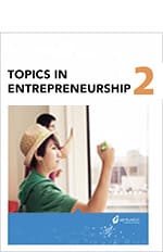 Cover of a textbook titled "Free Entrepreneurship Curriculum 2" featuring a young woman in a classroom, writing on a whiteboard.