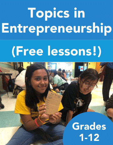 Two young students sitting in a classroom holding a paper, excitedly looking at the camera, with a blue poster titled "Entrepreneurship Curriculum for K-12 Students" featuring topics in entrepreneurship.