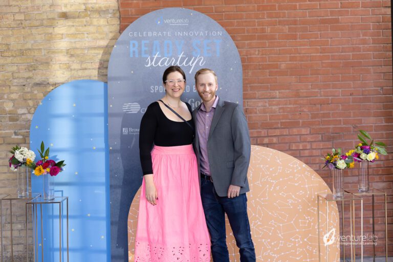 Two people stand in front of a 