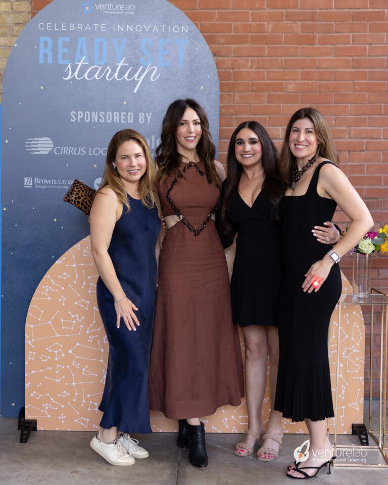Four women standing in front of a 