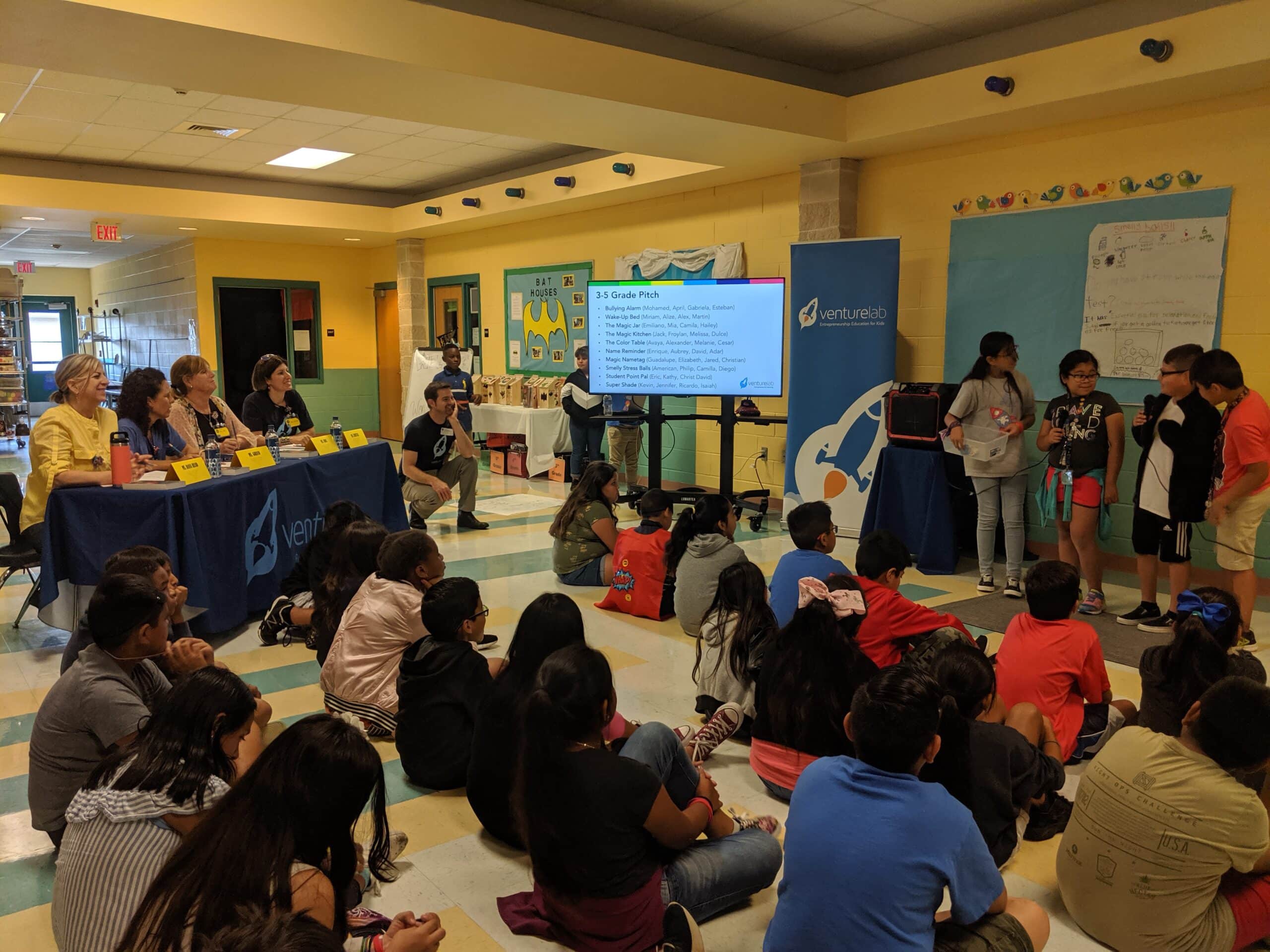 Students presenting in front of an audience and judges at a Youth Entrepreneurship Event.