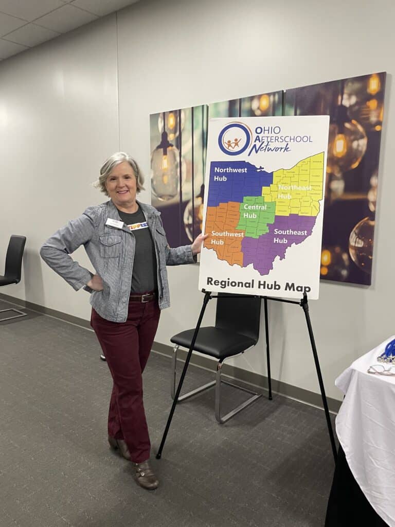 Liz Nusken standing next to display