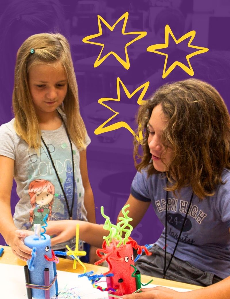 Two young girls collaborating on their business idea - a decorated pool noodle with markers attached.