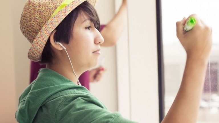 Teenage Girl Using Brainstorming to generate ideas by writing on Window