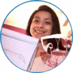 A smiling young woman involved in a social entrepreneurship program, holding up an open notebook and a pair of earphones close to the camera in a circular frame.